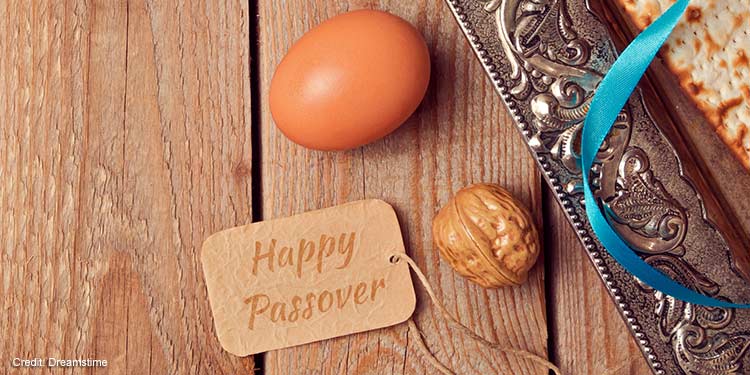 An egg and a walnut lying next to a small tag that reads Happy Passover