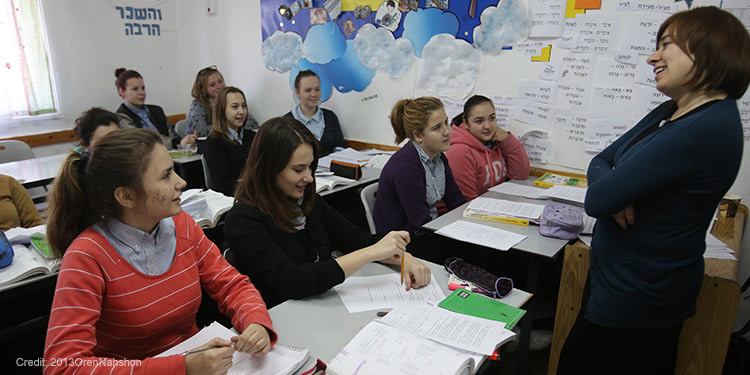 A teacher standing in front of her teenage students.