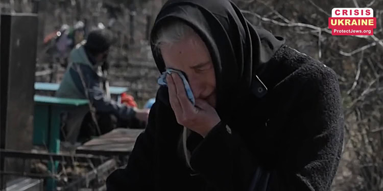 Woman grieving and praying outdoors amid crisis in Ukraine, highlighting the importance of supporting Jewish communities during times of conflict.