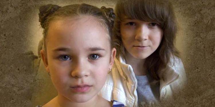 A young girl and her brother looking directly ahead with a vignette effect at the corners of the photo.