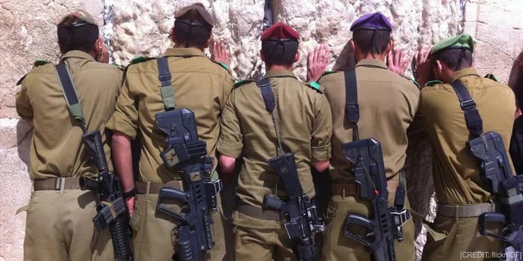 Five young soldiers praying at the Western Wall.