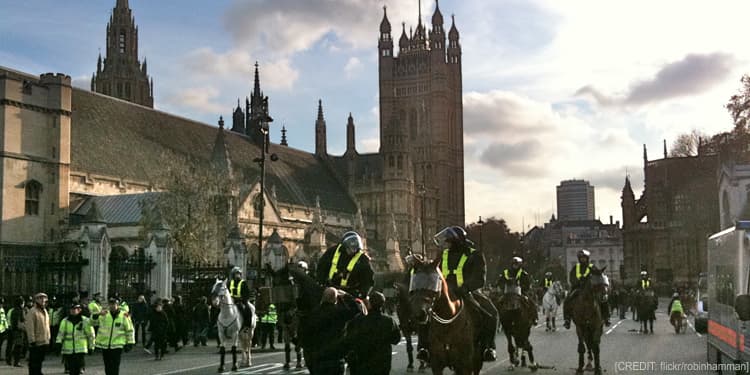 Policemen on horses walking down the streets of a city.