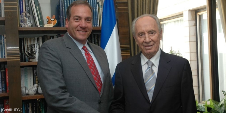 Rabbi Eckstein standing next to Peres in a library.
