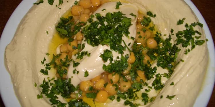 Homemade tehina with olive oil and parsley garnished on top.