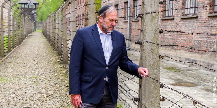 Rabbi Eckstein walking along a fenced path.