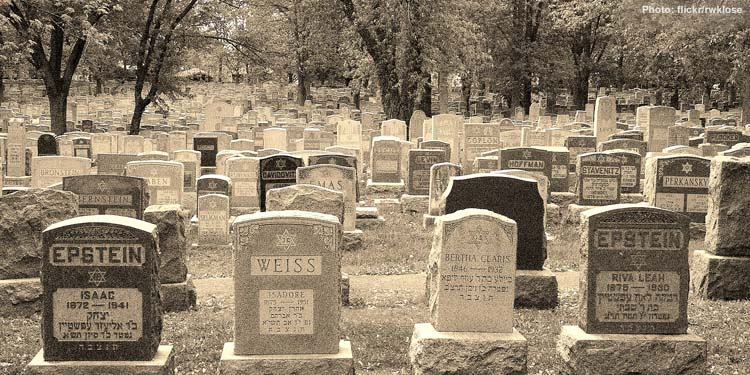Black and white image of tombstones in a cemetary.