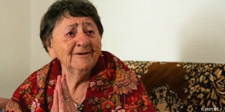 Elderly Jewish woman looking sad with hands together