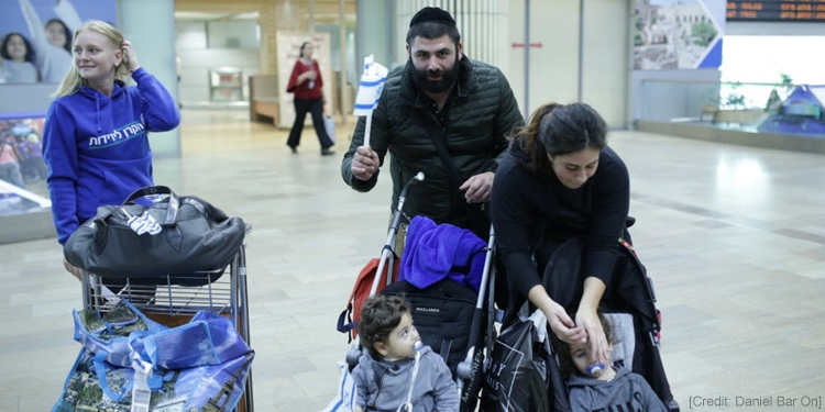 Two parents helping their two sons in the airport as a teenage girl in an IFCJ sweatshirt is beside them.