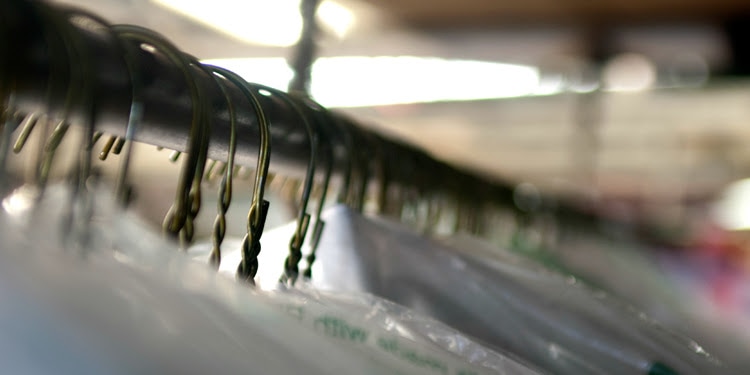 Close up image of clothes hangers hanging on a rail.