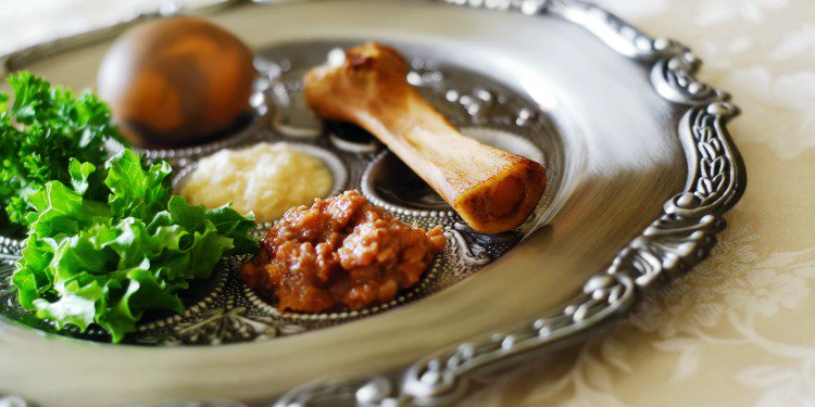 Seder plate with shank bone, egg, bitter herbs, and other food items.