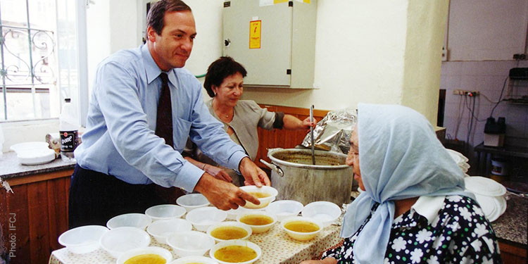 Rabbi Eckstein serves lunch to an elderly woman