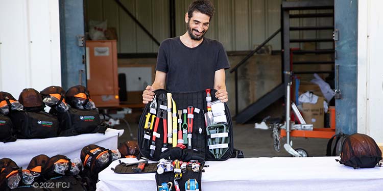 Adult man stand behind table with open emergency kit