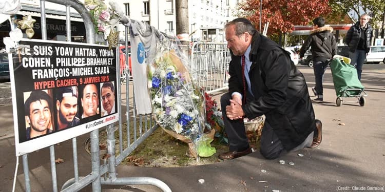Rabbi Eckstein kneeling down at a memorial in France.