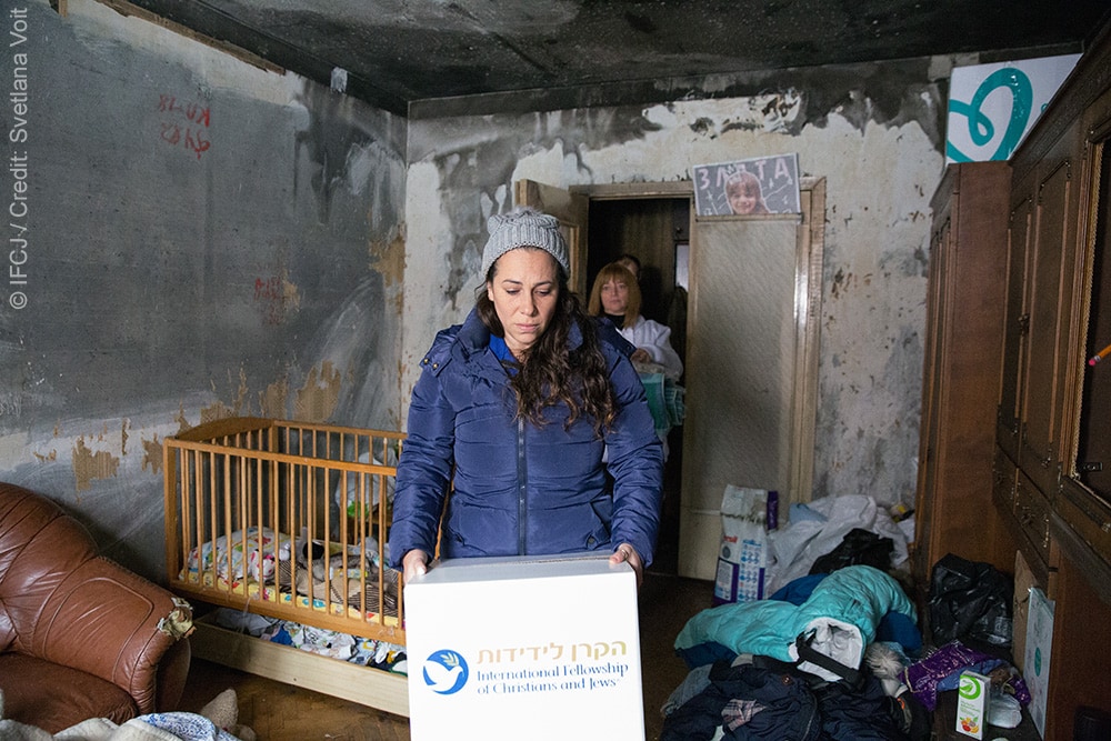 Yael walking through a home with an IFCJ food box.