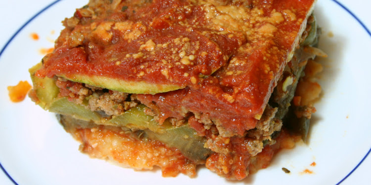 Close up image of vegetable lasagna on a white and blue plate.