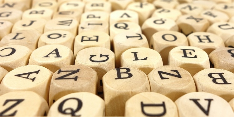 Close up of wood cubes that have letters on them.
