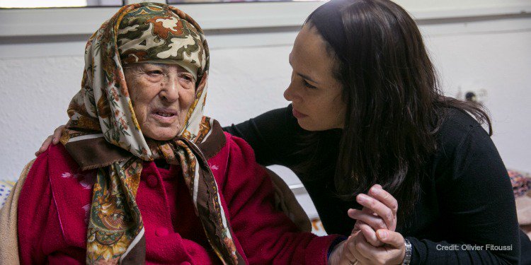 Yael Eckstein holds the hand of an elderly Jewish woman living in poverty who needs a friend of Israel