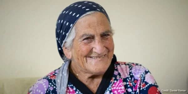 Elderly Jewish woman in bandana looking off into the distance.