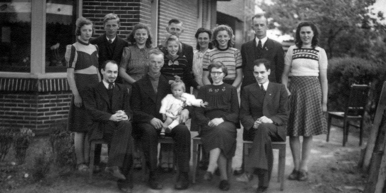 Fourteen members of the Zeestraten family posing together for a family picture.